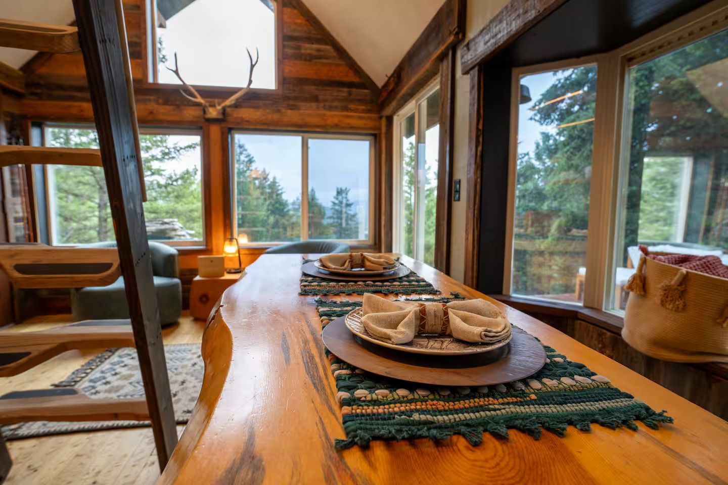 A wooden table with plates and napkins on it in a cabin.