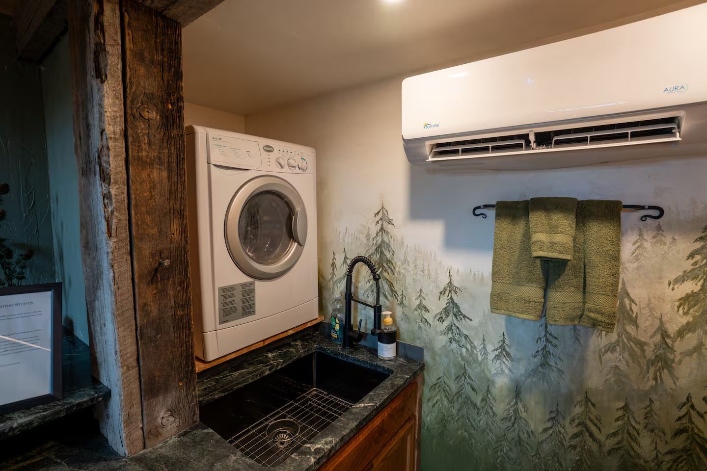 A laundry room with a washer and dryer and a sink.