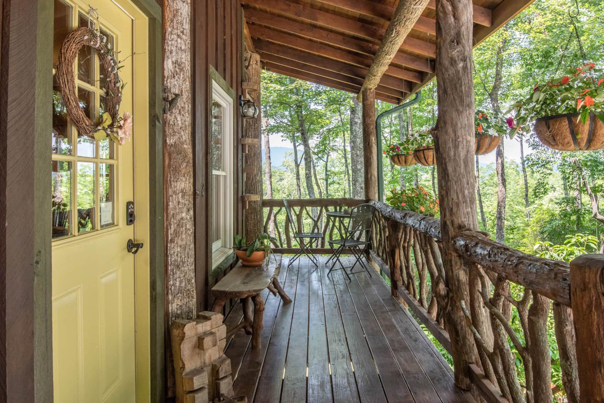 There is a porch with a wooden railing and a yellow door.