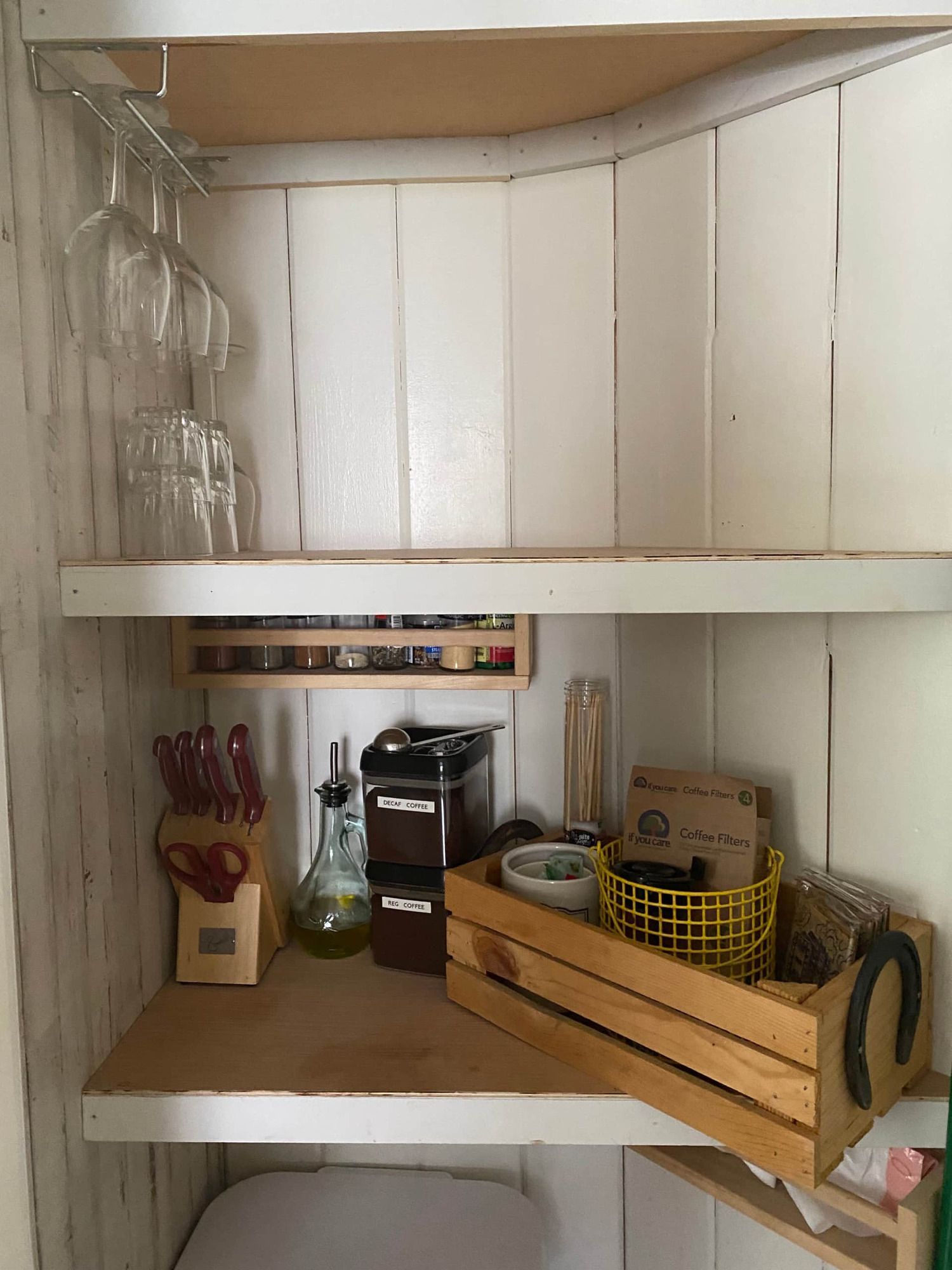 A wooden crate sits on a wooden shelf in a kitchen