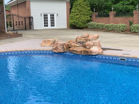 inground pool with rock formation on edge