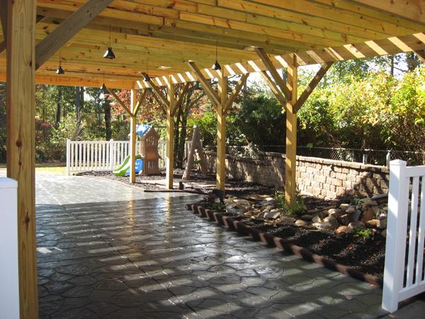 stone pattern patio with pergola and rock garden