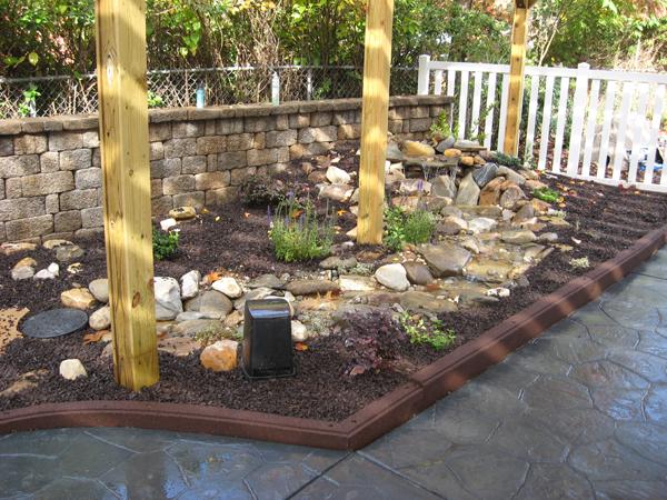 stone pattern patio along side of rock garden