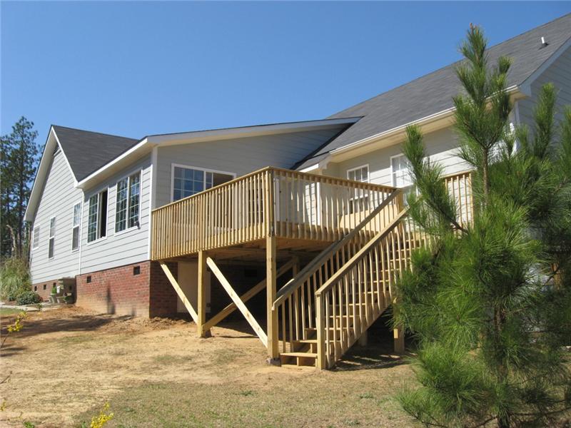deck on back of grey house with staircase