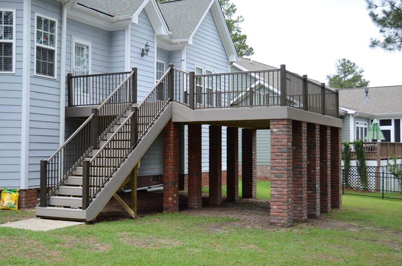 newly constructed deck painted gray with brick footers
