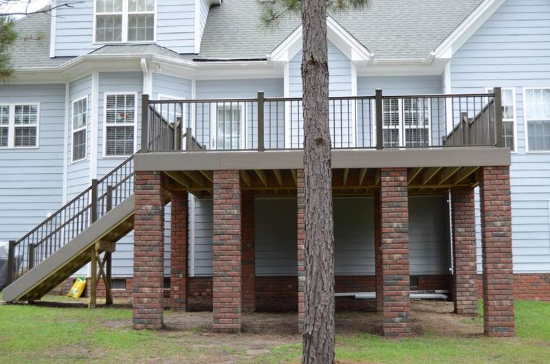 back of new gray deck with brick footers