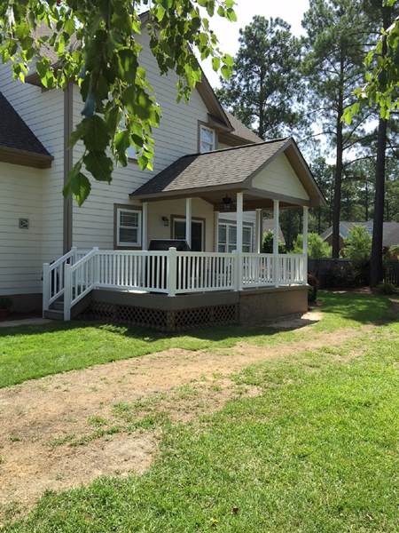 deck with covered porch and white railing