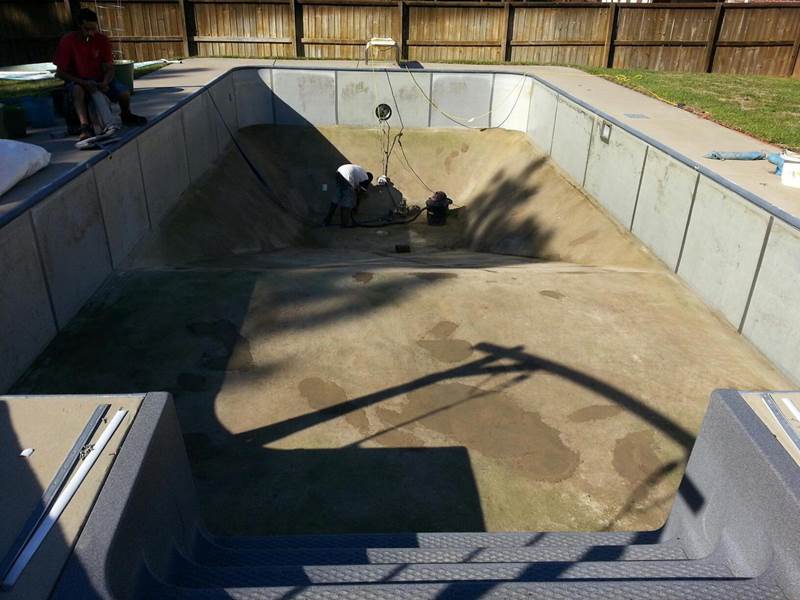 2 workers repairing inground pool