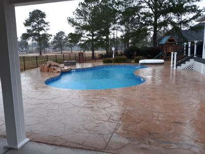 stone pool decking surrounding kidney shape pool