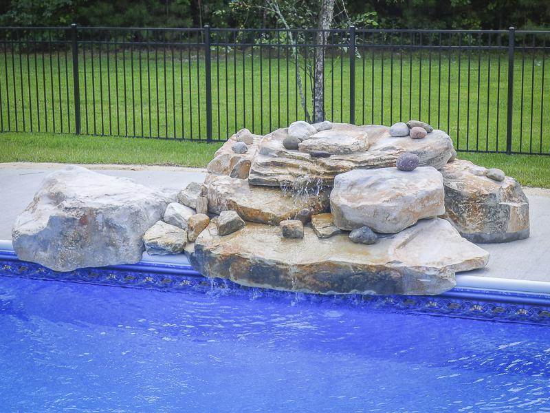 rock formation waterfall on edge of pool