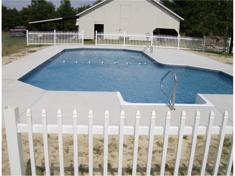 inground pool with white picket fence