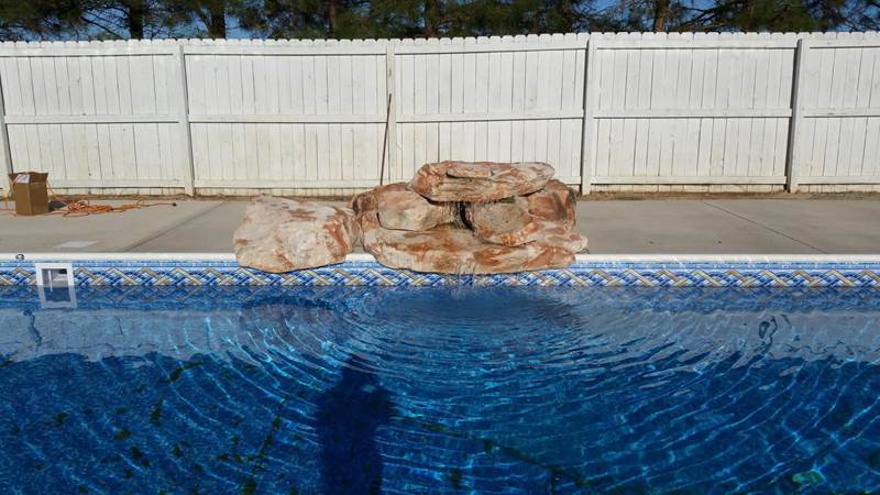 rock formation waterfall on edge of pool