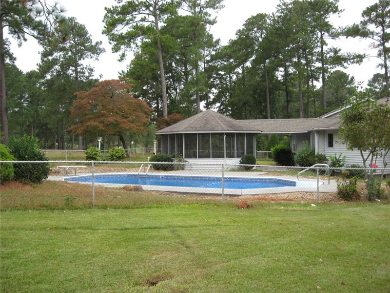 back of house with inground pool and fence surrounding