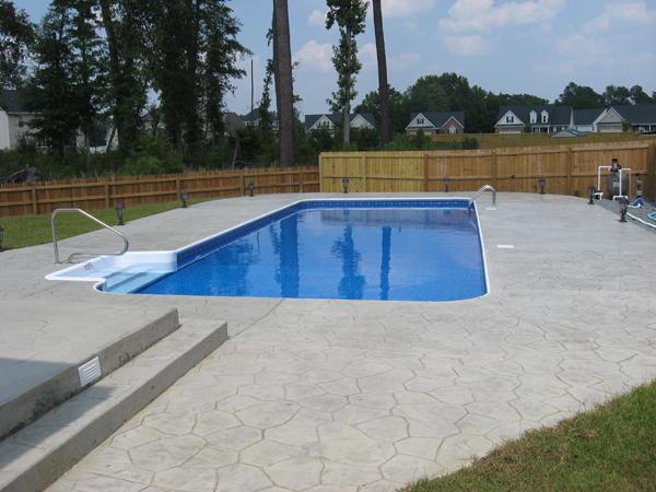 rectangle inground pool with gray stone patio surround