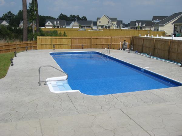 inground pool with gray stone patio surround