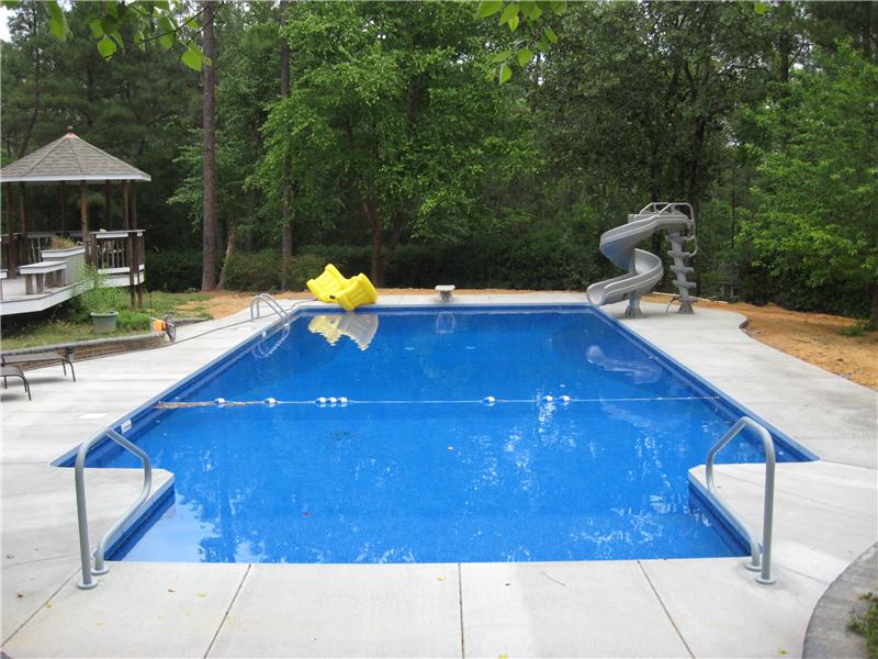 inground pool with twisted slide and diving board