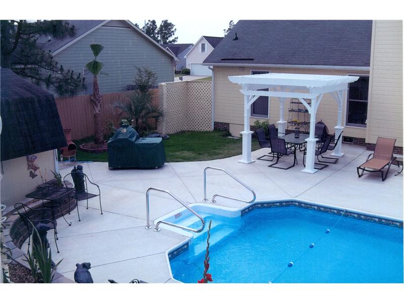 inground pool with pergola over patio set