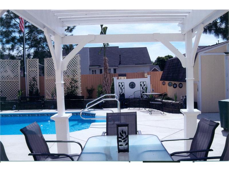 view of pool from under pergola structure