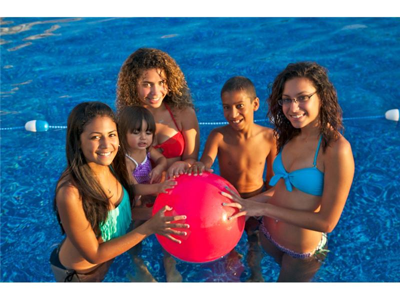 5 kids standing in pool holding pink ball