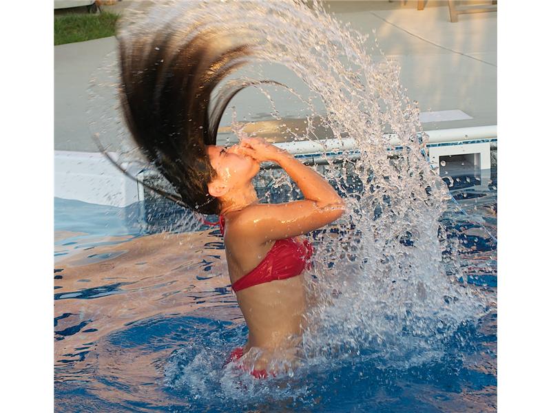 girl jumping out of  water flipping her hair