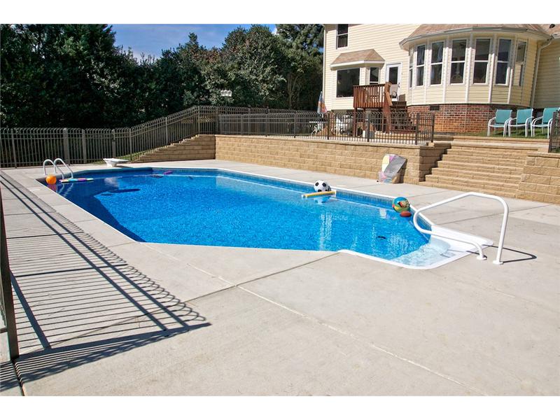 pool with toys floating and stairs leading to top tiered patio