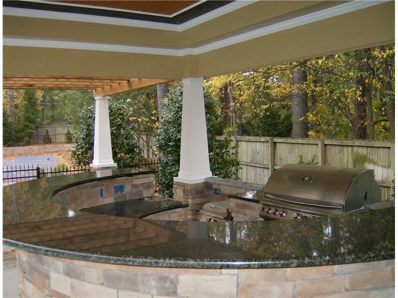 2 tiered granite countertop and grill in outdoor kitchen