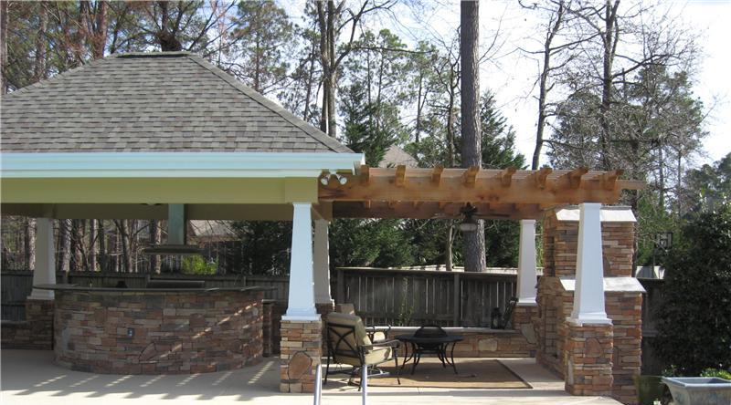covered outdoor kitchen and pergola structure attached with brick fireplace