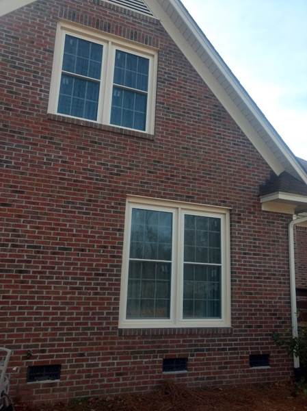 2 double windows on side of brick house