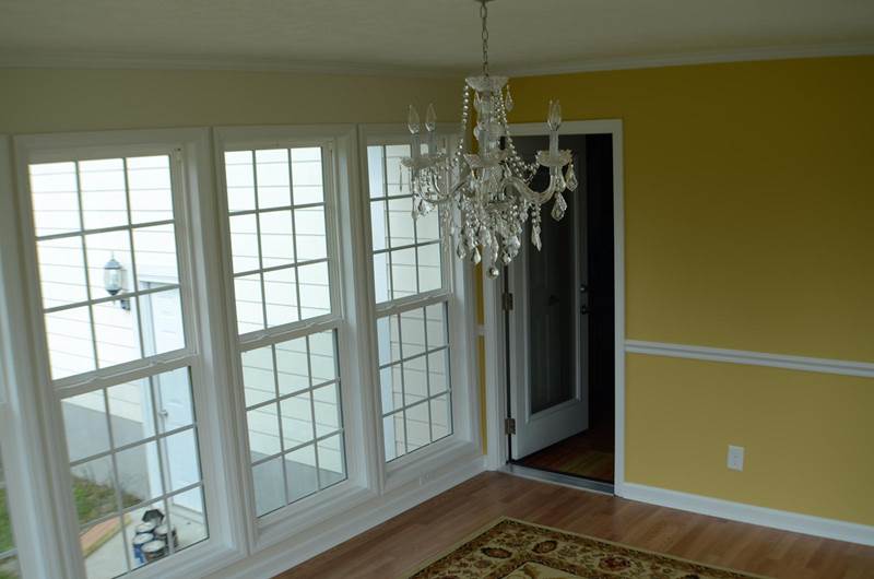 Inside view of sunroom with door leading into house with crystal chandelier