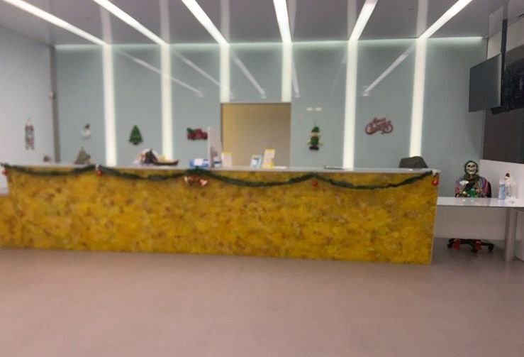 A picture of a hotel lobby with a long yellow counter.