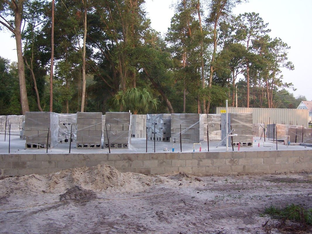 A construction site with a fence and trees in the background