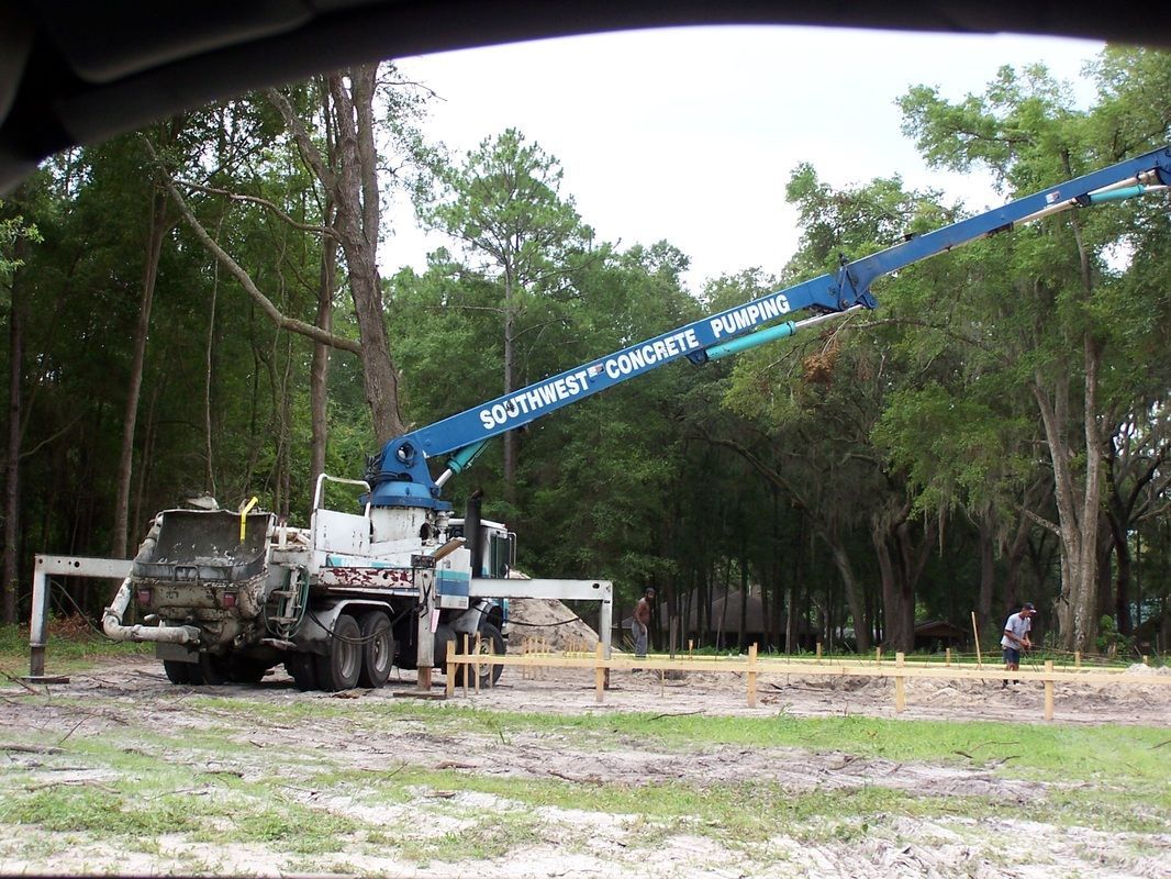 A concrete pump is being used to pump concrete into a hole in the ground.