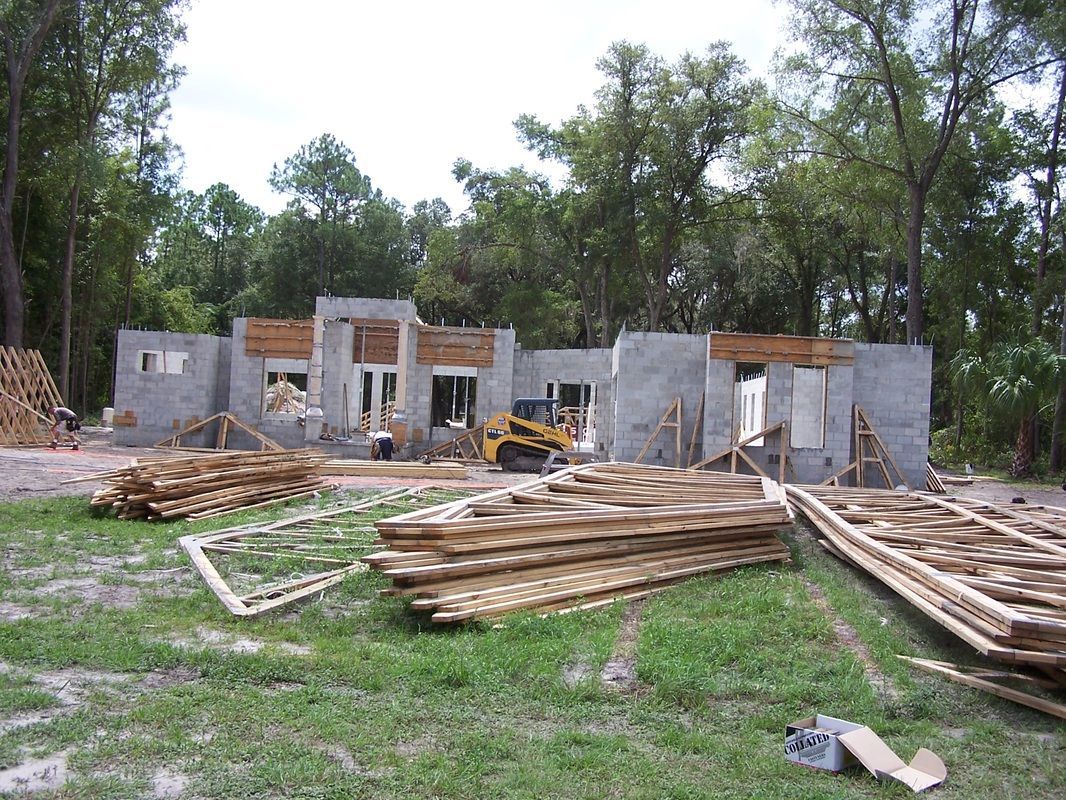 A house is being built with a lot of wood in front of it