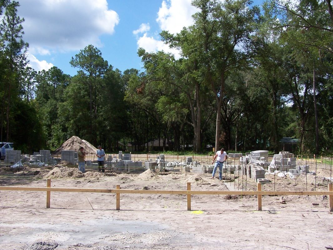 A construction site with a wooden fence and trees in the background