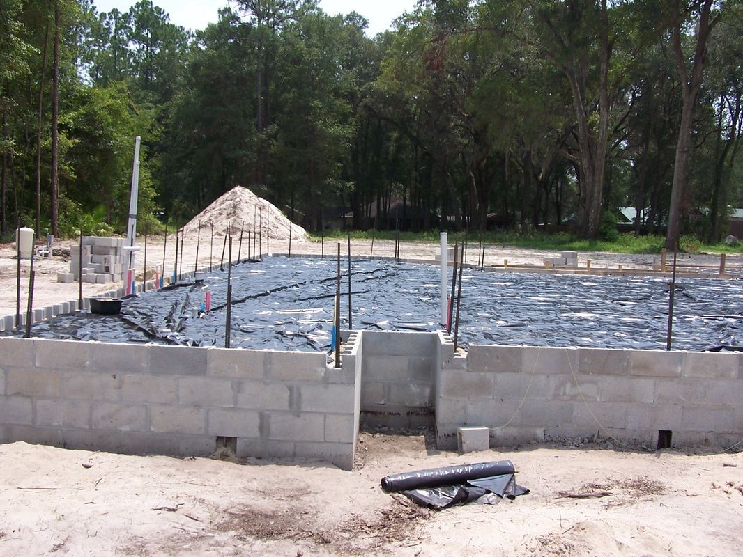 A construction site with a lot of concrete blocks and trees in the background