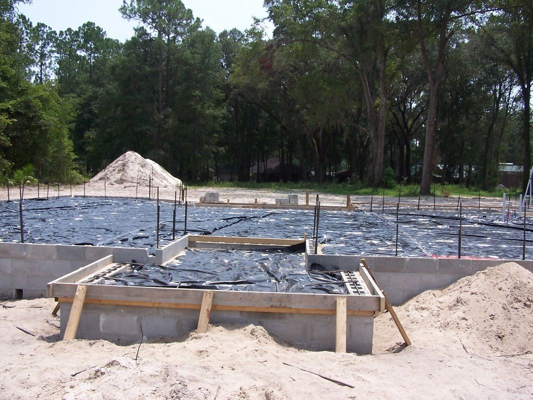 A construction site with a lot of sand and trees in the background