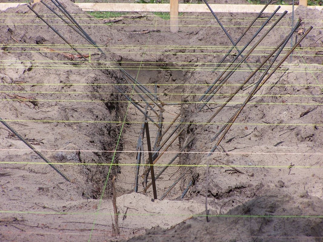 A bunch of metal rods are sitting in the dirt.