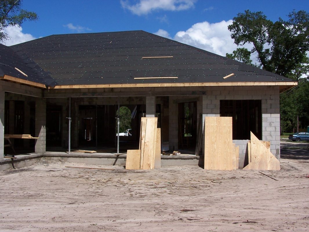A house that is being built with a black roof