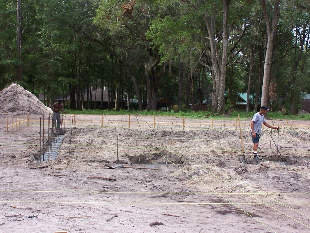 A man is standing in the middle of a muddy field.