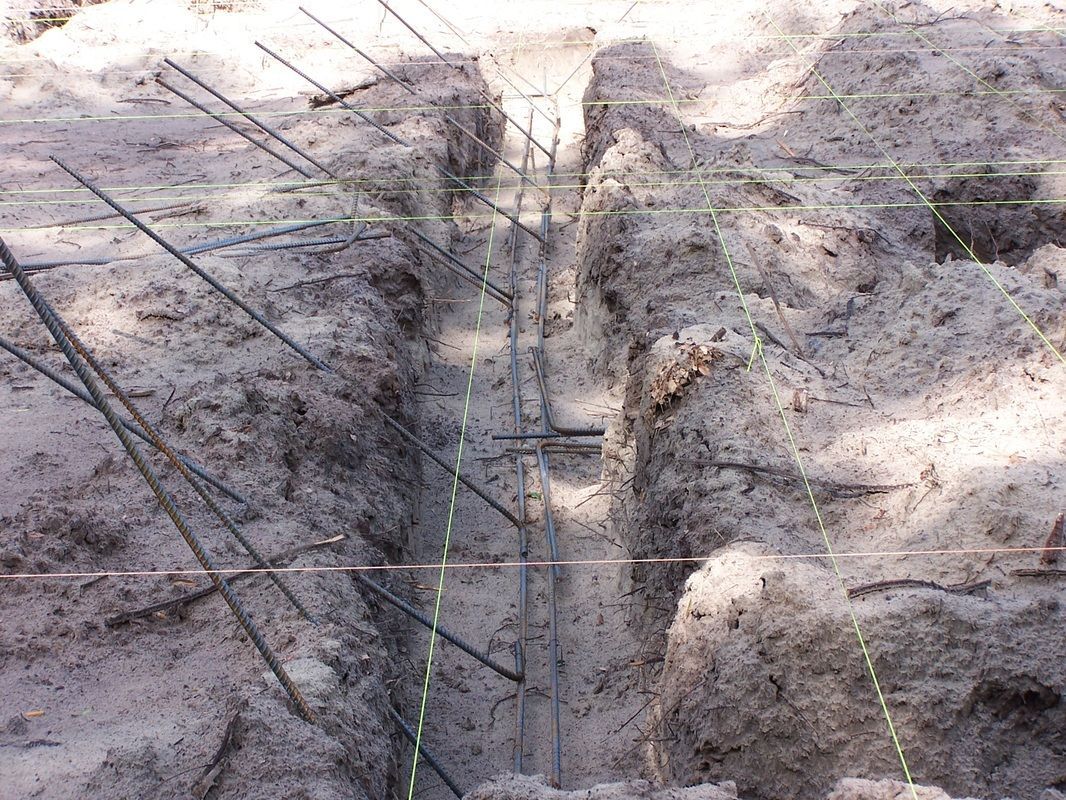 A hole in the ground with a bunch of metal bars in it.