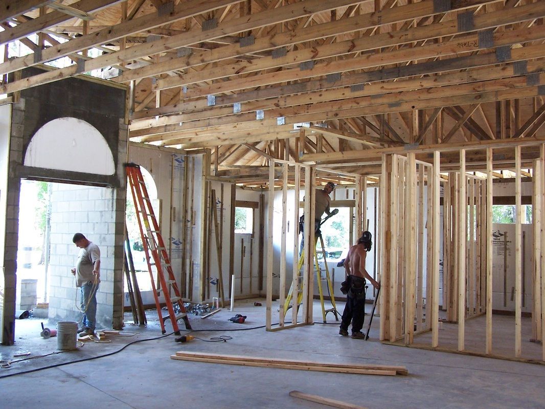 A man is standing in the middle of a building under construction.