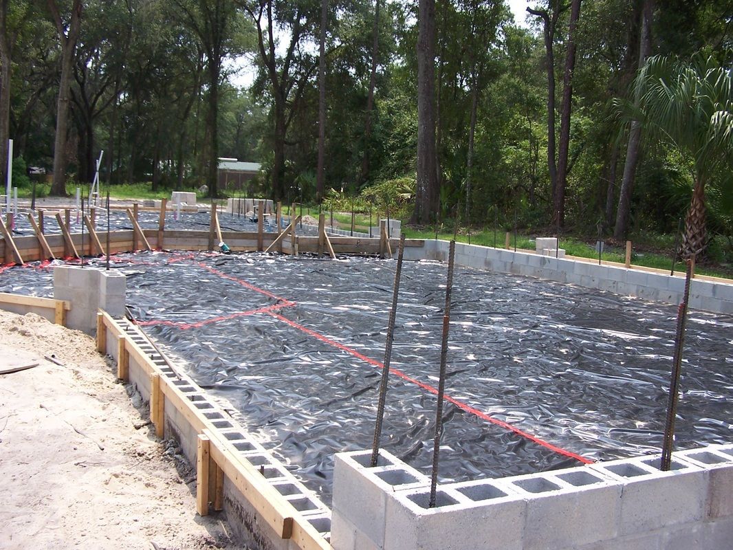 A construction site with a lot of concrete blocks and trees in the background