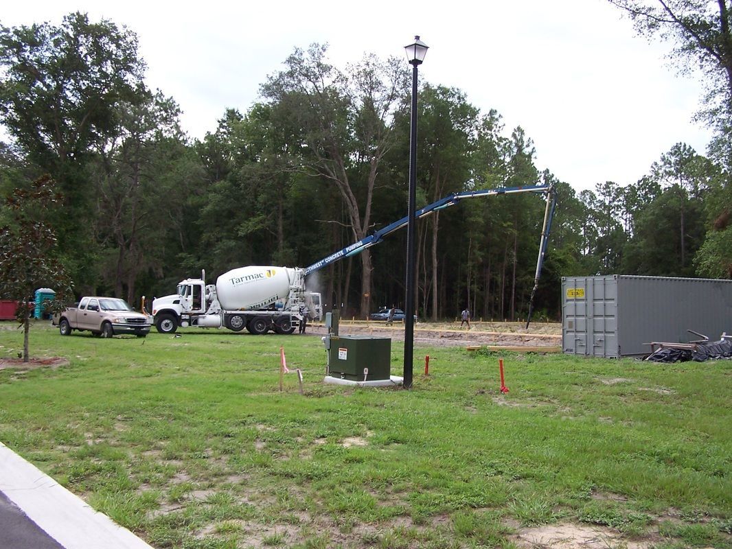 A concrete truck is driving through a grassy field