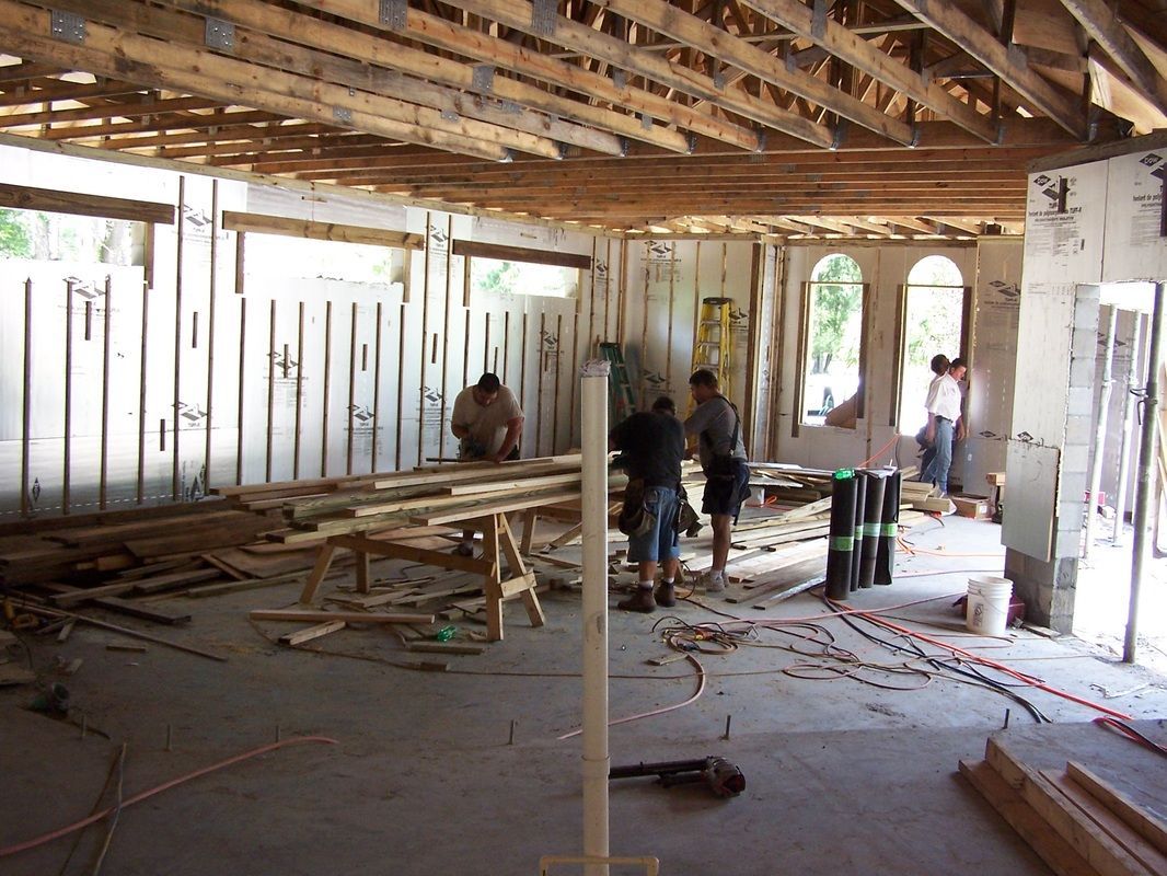 A group of people are working on a building under construction.