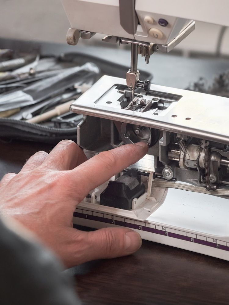 A Person is Fixing a Sewing Machine With Their Finger — James Hunter Mobile Sewing Machine Mechanic in Battery Hill, QLD