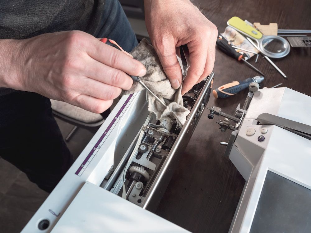 A Person is Cleaning a Sewing Machine With a Cloth — James Hunter Mobile Sewing Machine Mechanic in Battery Hill, QLD