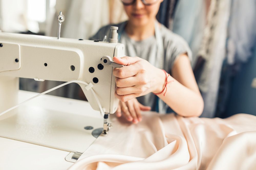 A Woman is Using a Sewing Machine to Sew a Piece of Fabric — James Hunter Mobile Sewing Machine Mechanic in Maroochydore, QLD