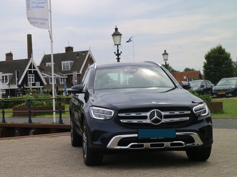 Een mercedes benz suv staat geparkeerd voor een huis