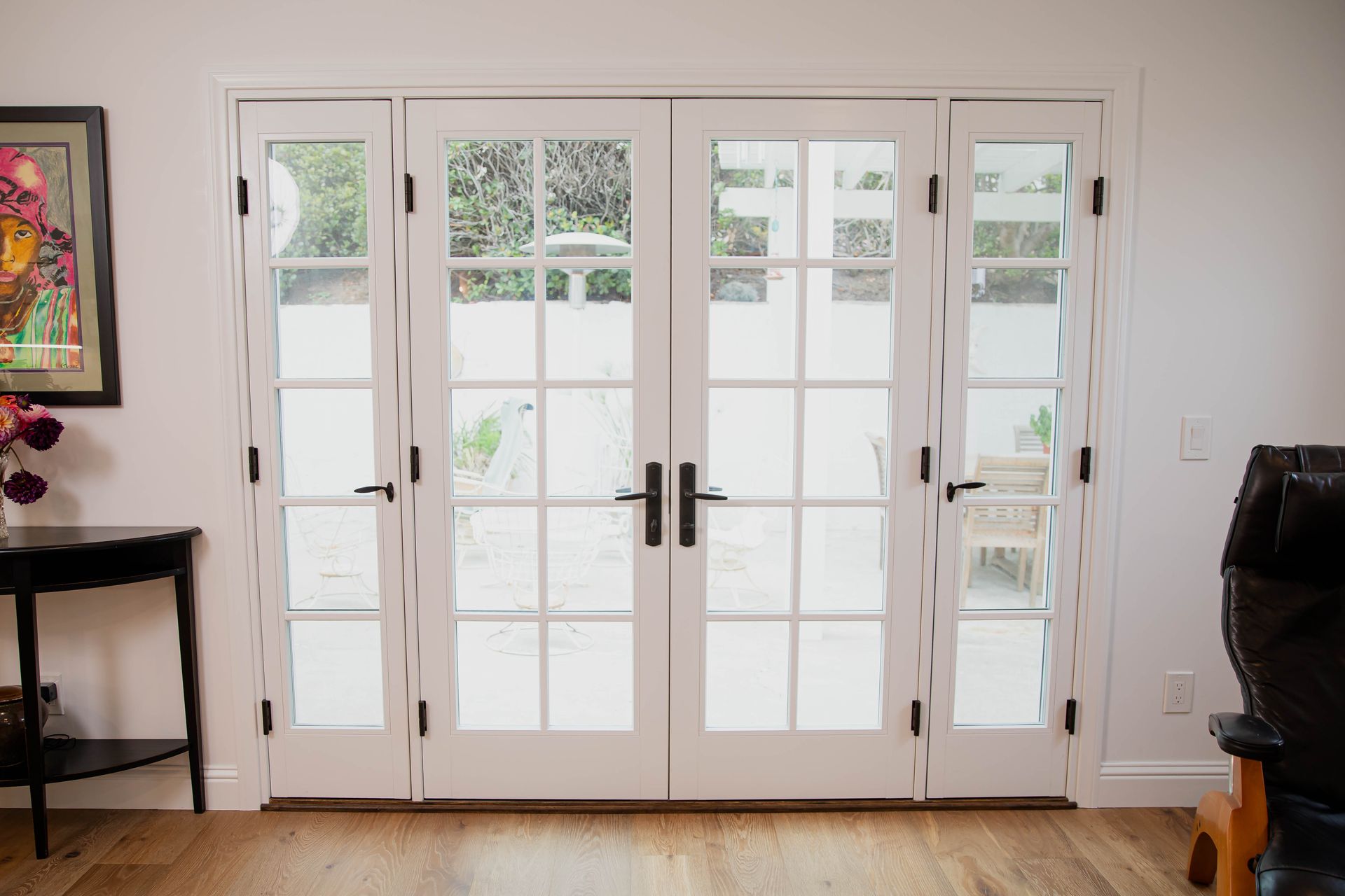 A living room with a table and chairs and a painting on the wall.