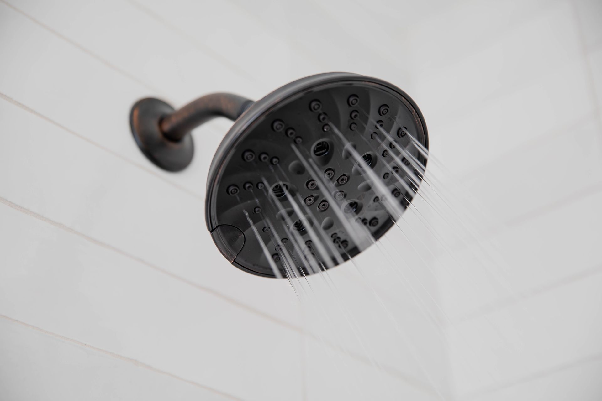 A close up of a shower head with water coming out of it.